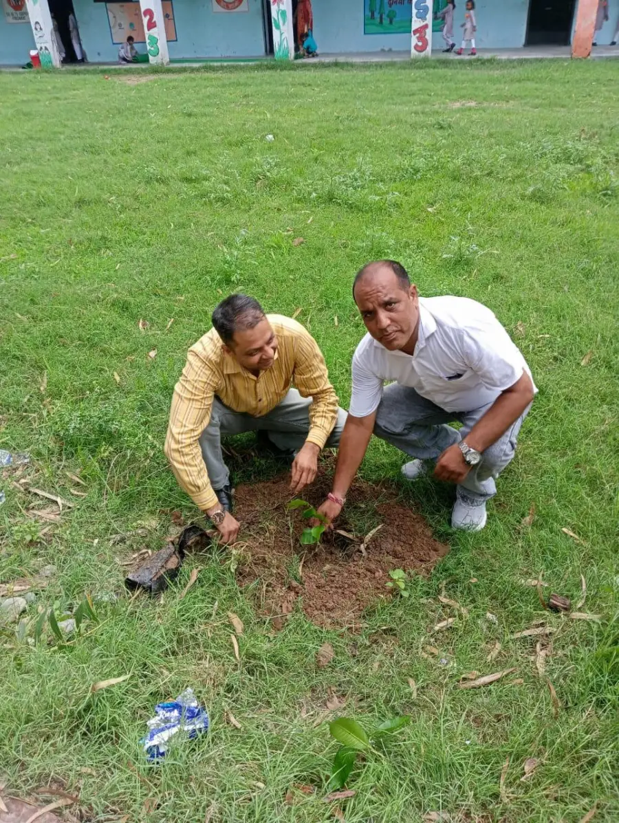 Two staff members planting a sapling at Government Girls Middle School